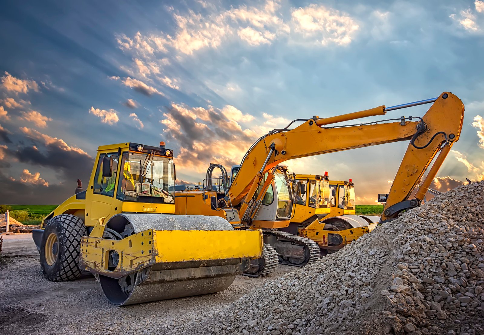 Vibrocompactador y excavadora en obra